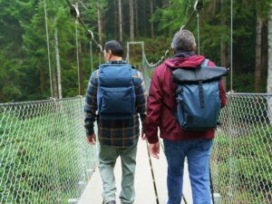 Two men mount the suspension bridge over Amanda Creek