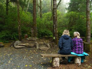Two women seated on a bench in the amphitheater at the Amanda grotto
