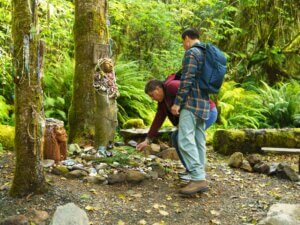 Two men examine offerings at the Amanda statue