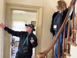 Two women stand on a staircase inside the Yaquina Bay Lighthouse