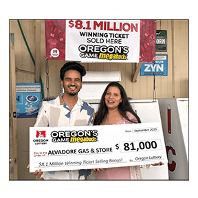 Two smiling individuals are holding an oversized novelty check for Oregon's Game Megabucks. The are standing inside of a convenience store underneath a banner reading "$8.1 Million winning ticket sold here"